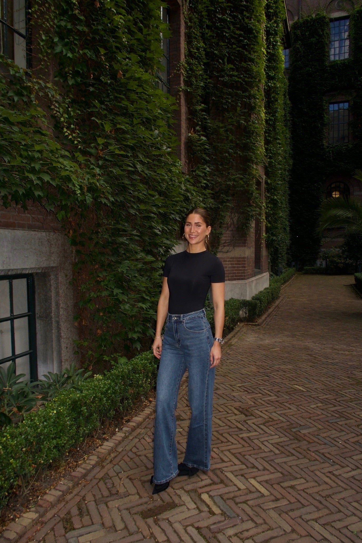 straight leg jeans in a dark wash paired with a black short sleeve body women
