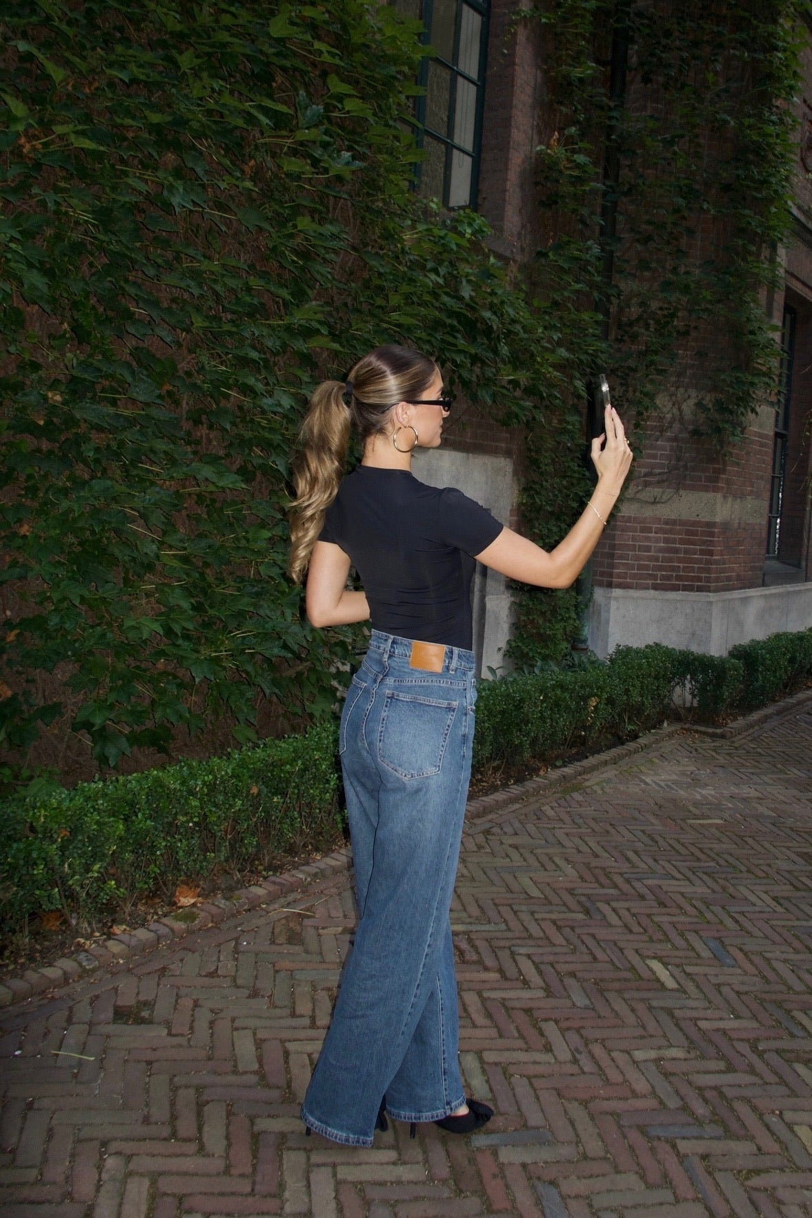 straight leg jeans in a dark wash paired with a black body short sleeve women